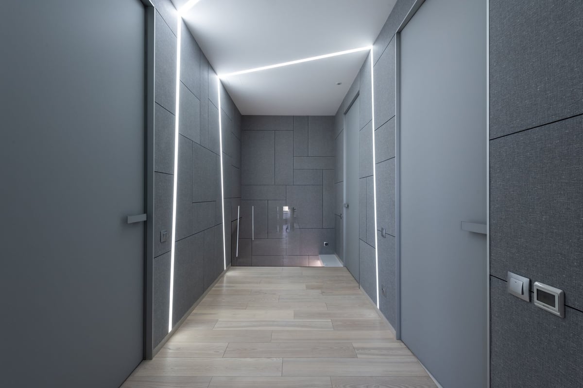 Couloir d'appartement éclairé par des bandeaux LED encastrés au plafond et aux murs